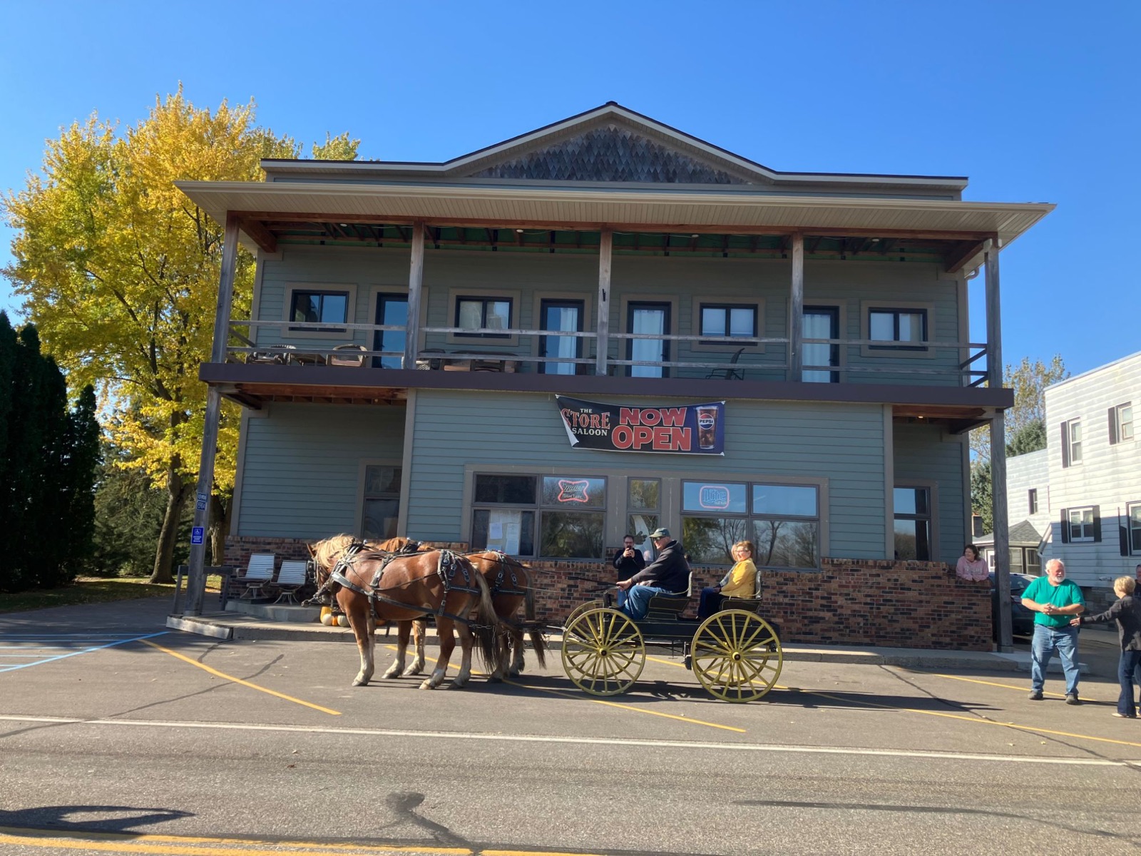 The Store Saloon building with a horse-drawn carriage out front and a Now Open banner